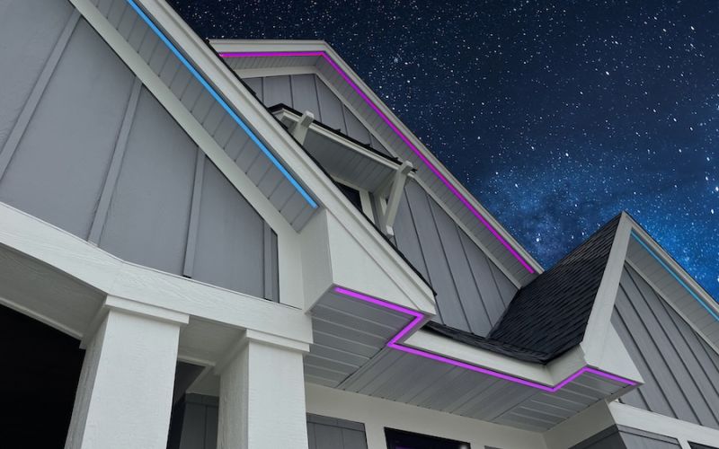 <span class="uk-h4">Home rooflines outlined in blue and pink permanent lighting against a starry night sky at Prior Lake.</span>
