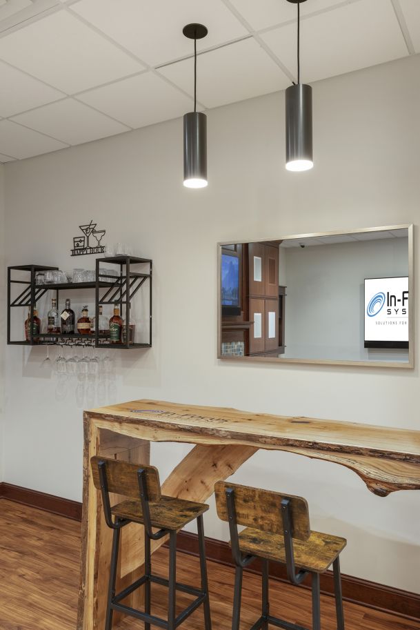 Bar counter with wood slab table, stools, and mirrored TV